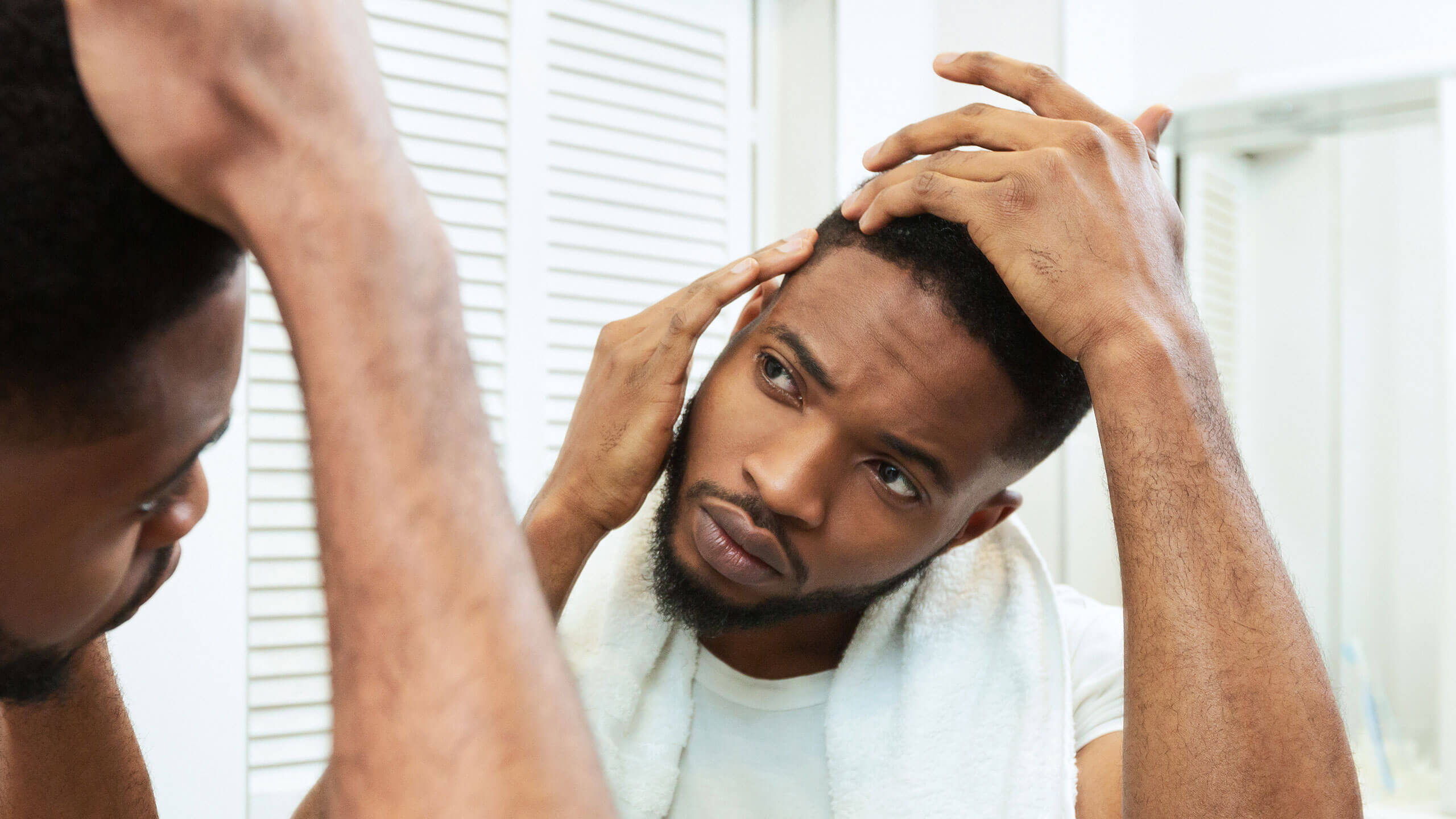 a man inspecting the hair on the side of his head