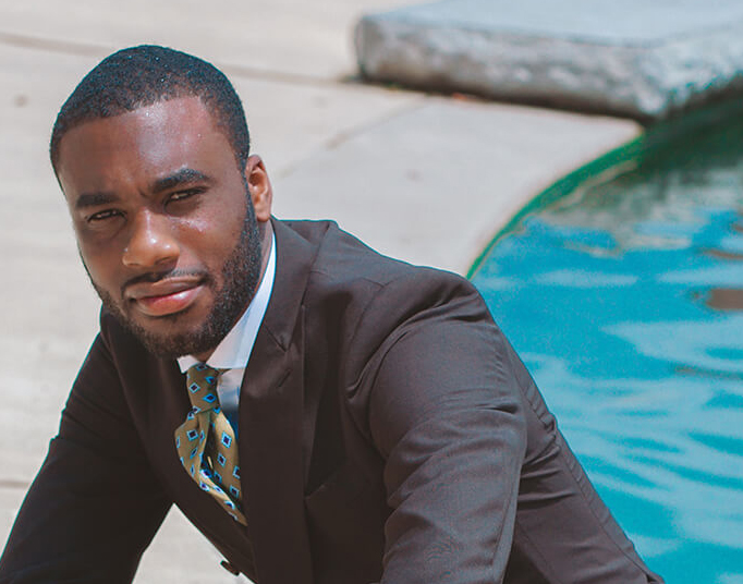 close up of a well-groomed man in a business suit with a pool in the background